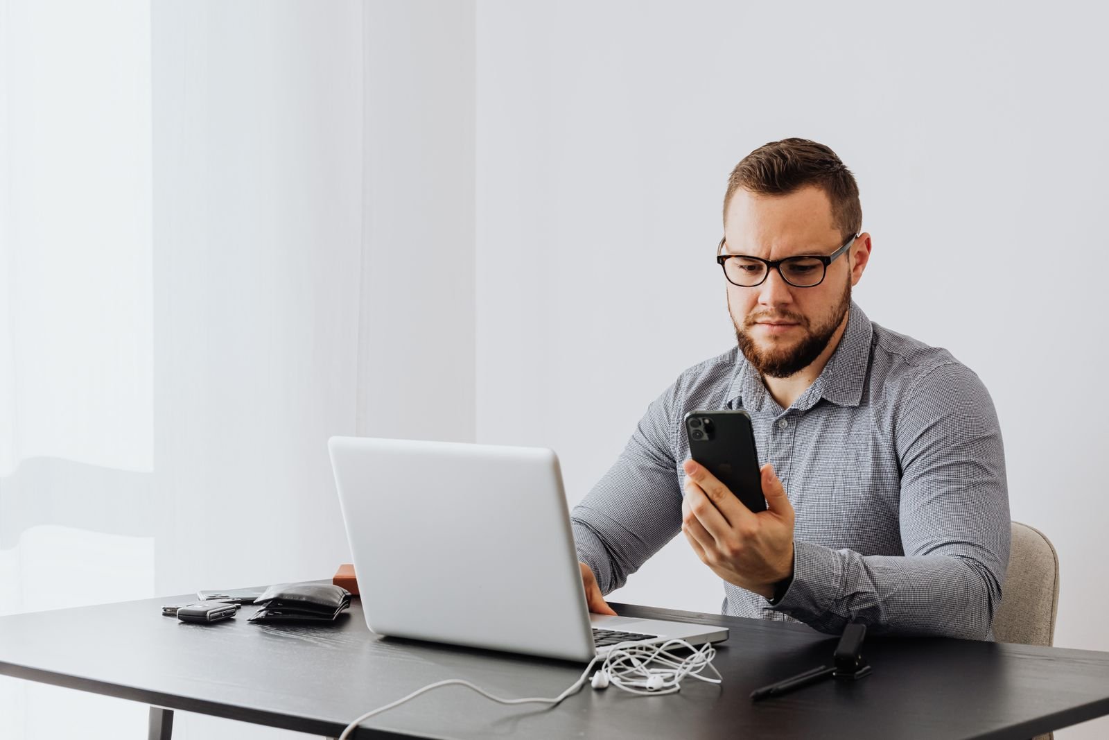 Business owner calmly checking data on a laptop and phone instead of reacting to a ranking swing