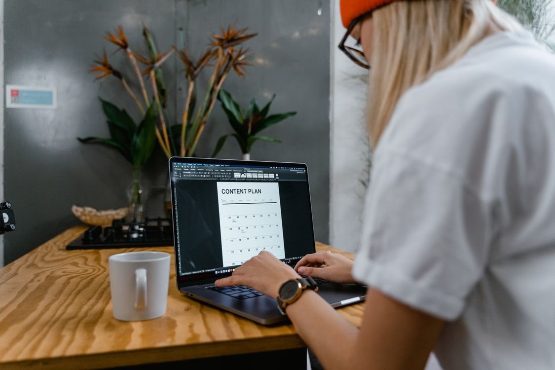 Business owner typing on a laptop to update website content and FAQ answers that AI tools like Ask Maps read when answering customer questions about a Google Business Profile