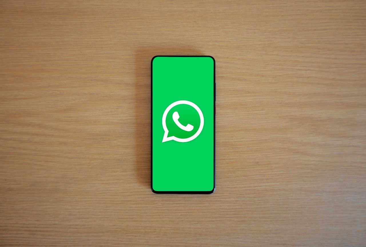 Smartphone displaying the WhatsApp logo, representing the WhatsApp Business Profile contact option now available on Google Business Profile