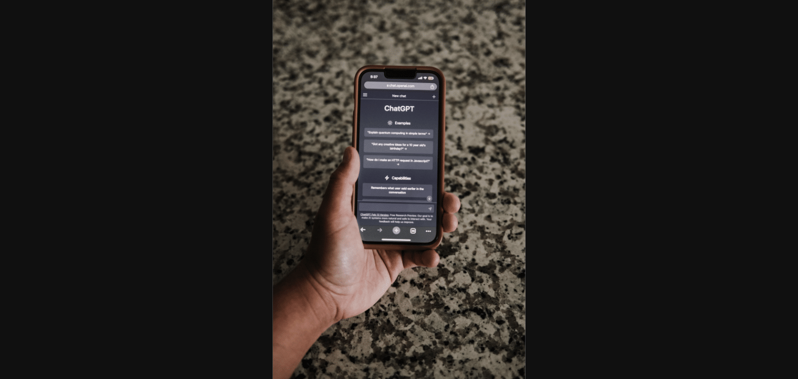 Hand holding a phone with the ChatGPT app open, representing where ChatGPT Ads appear to users