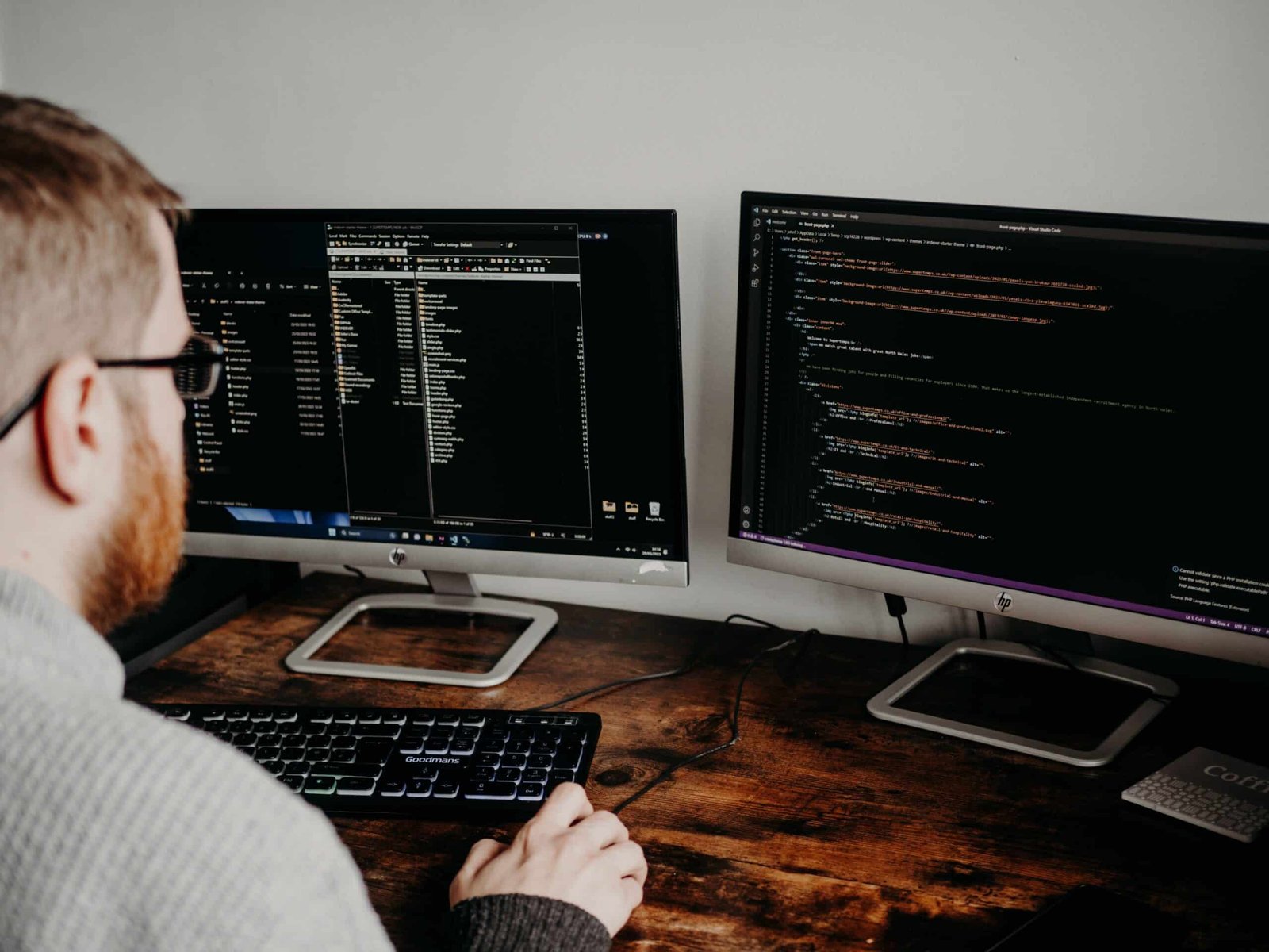 Web developer updating a WordPress website on two monitors