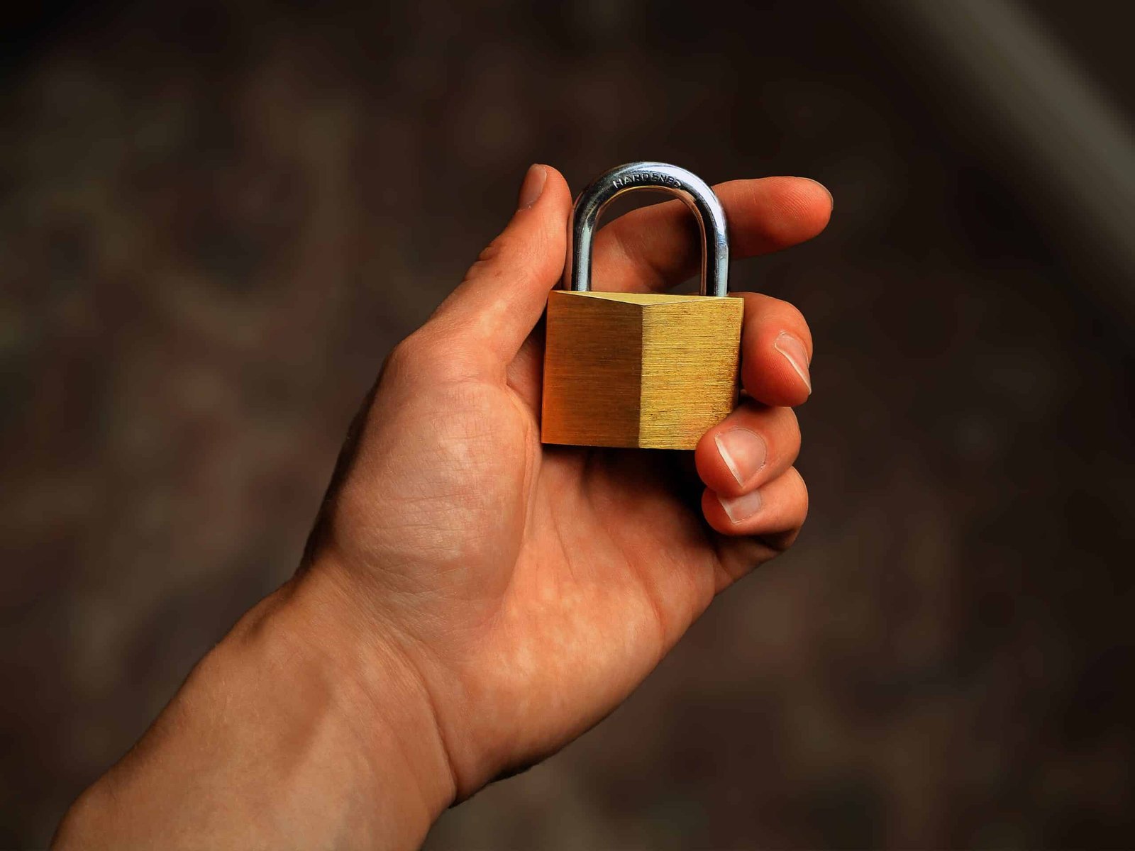 Hand holding a brass padlock to represent a WordPress security update protecting a business website